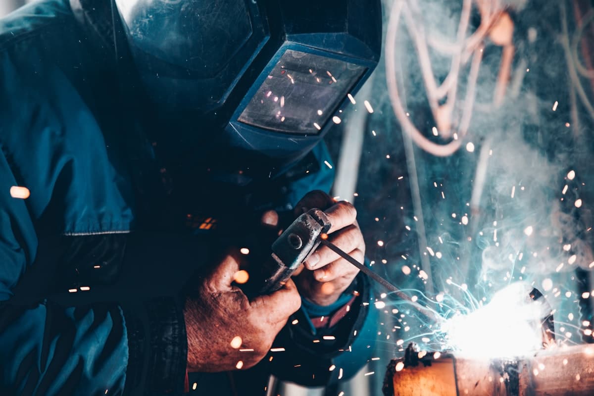 A tradesperson welding a metal joint